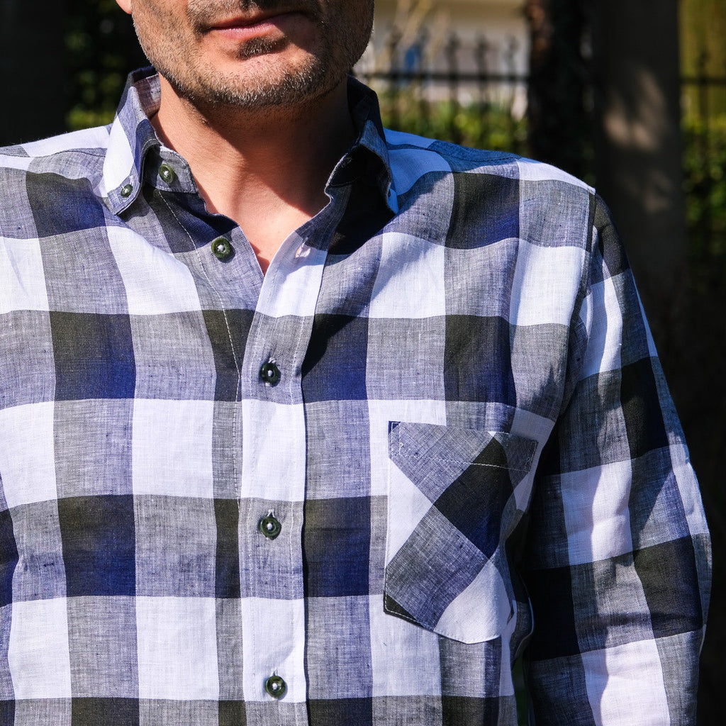 Man wearing a blue and white checkered shirt outdoors